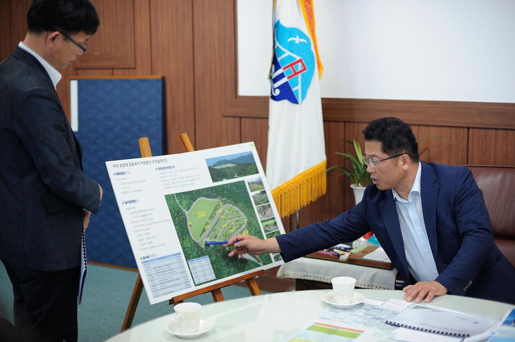 정현태 군수(오른쪽)가 미조삼정개 공동묘지 자연장지 조성공사 계획을 살펴보고 있다